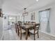 Dining room with seating for eight and modern light fixture with view into Gathering room at 5231 32Nd E St, Bradenton, FL 34203