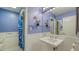 Stylish bathroom featuring blue walls, a pedestal sink, and a shower with a patterned curtain at 5324 Siesta Ct, Sarasota, FL 34242
