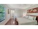Cozy bedroom with hardwood floors, a comfortable bed, and natural light from a large window at 5324 Siesta Ct, Sarasota, FL 34242