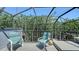 Screened patio with comfortable seating, offering a view of lush greenery and blue sky at 5324 Siesta Ct, Sarasota, FL 34242