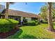 Townhouse backyard featuring beautiful landscaping, green grass, and a cozy screened-in lanai at 5354 Myrtle Wood # 50, Sarasota, FL 34235