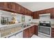 Kitchen featuring stainless steel appliances, granite countertops, and dark wood cabinets at 5354 Myrtle Wood # 50, Sarasota, FL 34235