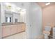 Modern bathroom with double sinks, granite countertops, and stylish lighting fixtures at 5554 Blue Azure Dr, Wimauma, FL 33598