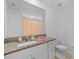 Well-lit bathroom with granite countertop vanity, a sink, a toilet and neutral color palette at 5554 Blue Azure Dr, Wimauma, FL 33598