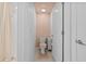 Cozy bathroom featuring a toilet with pink accents, a small storage unit and a shower with a patterned curtain at 5554 Blue Azure Dr, Wimauma, FL 33598