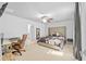 Spacious bedroom with a large bed, ceiling fan, and desk area at 5554 Blue Azure Dr, Wimauma, FL 33598