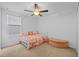 Cozy bedroom with carpet flooring, a ceiling fan, a window, and a futon bed with butterfly-themed bedding at 5554 Blue Azure Dr, Wimauma, FL 33598