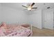 Inviting bedroom featuring carpet flooring, a ceiling fan, and a futon bed with butterfly-themed bedding at 5554 Blue Azure Dr, Wimauma, FL 33598