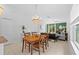 Bright dining area with a wooden table, elegant chandelier, and seamless flow into the inviting living space at 5554 Blue Azure Dr, Wimauma, FL 33598