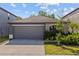 Charming single-story home featuring a two-car garage, manicured lawn, and tasteful landscaping, creating inviting curb appeal at 5554 Blue Azure Dr, Wimauma, FL 33598