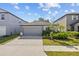 Charming single-story home featuring a two-car garage, manicured lawn, and tasteful landscaping, creating inviting curb appeal at 5554 Blue Azure Dr, Wimauma, FL 33598