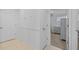 Hallway featuring paneled wainscotting, neutral tile flooring, and a bedroom with a gray dresser at 5554 Blue Azure Dr, Wimauma, FL 33598