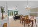 This open-concept living space boasts tile floors, a modern chandelier and seamless flow into the dining area at 5554 Blue Azure Dr, Wimauma, FL 33598