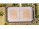 Aerial view of community pickleball court with fence and surrounding greenery at 5554 Blue Azure Dr, Wimauma, FL 33598