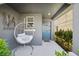 Inviting front porch with a cozy hanging chair and stylish decor at 5554 Blue Azure Dr, Wimauma, FL 33598