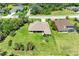 Aerial view of a one-story house featuring a meticulously kept yard surrounded by tree growth on a sunny day at 5616 90Th Avenue E Cir, Parrish, FL 34219