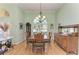 Formal dining room with elegant chandelier, hardwood floors, and large windows overlooking the yard at 5616 90Th Avenue E Cir, Parrish, FL 34219