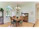 Formal dining room with elegant chandelier, hardwood floors, and large windows overlooking the yard at 5616 90Th Avenue E Cir, Parrish, FL 34219
