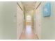 Bright hallway with tile flooring, closet doors, and an arched opening to the primary bathroom at 5616 90Th Avenue E Cir, Parrish, FL 34219
