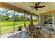 Inviting screened-in lanai provides relaxing outdoor seating with views of lush greenery and a ceiling fan at 5616 90Th Avenue E Cir, Parrish, FL 34219