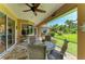 Inviting screened-in lanai provides relaxing outdoor seating with views of lush greenery and a ceiling fan at 5616 90Th Avenue E Cir, Parrish, FL 34219