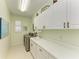 Well-lit laundry room offering sleek washer and dryer, complemented by ample cabinetry and a utility sink at 5616 90Th Avenue E Cir, Parrish, FL 34219