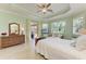Spacious main bedroom with tray ceiling, tile flooring, and a sliding glass door leading to the backyard at 5616 90Th Avenue E Cir, Parrish, FL 34219