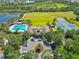 Aerial view of a community pool, clubhouse, tennis courts and recreational area with lush greenery, landscaping and parking at 5919 100Th E Ave, Parrish, FL 34219