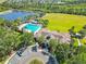 Aerial view of a community clubhouse, pool, lake and recreational area, featuring lush landscaping and parking at 5919 100Th E Ave, Parrish, FL 34219