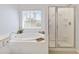Bright bathroom features soaking tub with jets and glass enclosed shower with tiled enclosure at 5919 100Th E Ave, Parrish, FL 34219