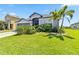 Well-manicured front lawn and garden surrounding a lovely single-story home with gray garage at 5919 100Th E Ave, Parrish, FL 34219