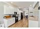 Charming kitchen boasting white cabinets, hardwood floors, and modern appliances with an open view to the dining area at 6838 44Th E Ter, Bradenton, FL 34203