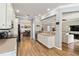 Bright kitchen featuring hardwood floors, white cabinetry, and an open floor plan to the living and dining area at 6838 44Th E Ter, Bradenton, FL 34203