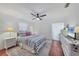 Bright bedroom with white walls, tile floor, ceiling fan, and beach-themed decor at 7114 11Th W Ave, Bradenton, FL 34209