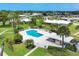 A sparkling pool area with lounge chairs, umbrellas, and a cabana, enveloped by lush landscaping and homes at 7114 11Th W Ave, Bradenton, FL 34209