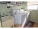 Functional laundry room with a utility sink, washer, dryer, and shelving at 7114 11Th W Ave, Bradenton, FL 34209