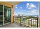 Balcony with iron railing overlooking city buildings, foliage, and the ocean with partly cloudy blue skies at 750 N Tamiami Trl # 1203, Sarasota, FL 34236