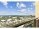 Balcony with iron railing overlooking a busy street with ocean, city buildings and blue skies in the distance at 750 N Tamiami Trl # 1203, Sarasota, FL 34236