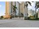 Elegant high-rise building with lush landscaping, a fountain, and a paved entrance at 750 N Tamiami Trl # 1203, Sarasota, FL 34236