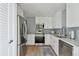 Bright kitchen with stainless steel appliances, light countertops, and blue tile backsplash at 750 N Tamiami Trl # 1203, Sarasota, FL 34236