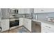 Bright kitchen with stainless steel appliances, light countertops and blue tile backsplash at 750 N Tamiami Trl # 1203, Sarasota, FL 34236
