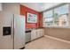 Kitchenette with stainless steel refrigerator, sink, dishwasher, framed artwork, and natural light at 750 N Tamiami Trl # 1203, Sarasota, FL 34236