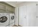 Convenient laundry area with modern washer and dryer units and built-in shelving for storage at 750 N Tamiami Trl # 1203, Sarasota, FL 34236