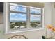 Bright window view overlooking lush green trees and the ocean with blue skies and clouds at 750 N Tamiami Trl # 1203, Sarasota, FL 34236