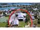 Aerial view of coastal home featuring pristine landscaping, a tennis court, and panoramic waterfront views at 763 Siesta Dr, Sarasota, FL 34242