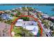 Aerial view of a home surrounded by lush greenery, a yard, and situated by a waterway at 763 Siesta Dr, Sarasota, FL 34242