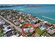 Aerial view of a charming coastal home with a tennis court, lush greenery, and breathtaking water views at 763 Siesta Dr, Sarasota, FL 34242