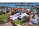 Stunning aerial view of a coastal home with lush landscaping and a tennis court by the serene water at 763 Siesta Dr, Sarasota, FL 34242