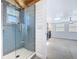 Updated bathroom featuring light blue tile shower and shiplap, with view into another room at 763 Siesta Dr, Sarasota, FL 34242