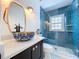 This contemporary bathroom features a stylish vanity and blue-tiled shower for a modern aesthetic at 763 Siesta Dr, Sarasota, FL 34242